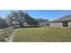 Expansive backyard with a large tree, offering ample space and privacy for outdoor activities at 521 Cardinal Dr, Poinciana, FL 34759
