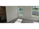 Bright bedroom featuring carpeted floors, two windows offering natural light, and a view of a bathroom at 521 Cardinal Dr, Poinciana, FL 34759