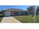 Charming single-story home with a well-manicured lawn and attached one car garage at 521 Cardinal Dr, Poinciana, FL 34759