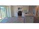 Kitchen with stainless steel appliances, white cabinets, and stylish gray flooring, creating a modern and functional space at 521 Cardinal Dr, Poinciana, FL 34759