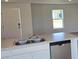 Modern kitchen island featuring a stainless steel dishwasher and a double sink, creating a sleek and functional workspace at 521 Cardinal Dr, Poinciana, FL 34759
