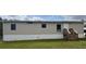 Exterior shot of manufactured home showing siding, stairs to front door, and front lawn at 3123 Crystal Hills Dr, Lakeland, FL 33801