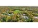 Expansive aerial view of a neighborhood, showcasing a large green space and mature trees at 3800 Levins Rd, Mulberry, FL 33860