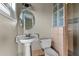 A bathroom features a pedestal sink, toilet, glass block window, and a tiled shower at 3800 Levins Rd, Mulberry, FL 33860