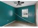 A small bedroom with a teal wall and a window at 3800 Levins Rd, Mulberry, FL 33860