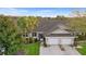 Aerial view of well-maintained home with two-car garage and lush landscaping at 26922 White Plains Way, Leesburg, FL 34748