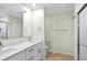 Bright bathroom with double vanity, quartz countertops, and tiled shower at 26922 White Plains Way, Leesburg, FL 34748