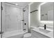 Renovated bathroom with marble-look tiled shower, modern vanity, and matte black hardware at 26922 White Plains Way, Leesburg, FL 34748