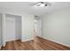 Bedroom features wood-look floors, ceiling fan, and closet at 26922 White Plains Way, Leesburg, FL 34748