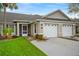 Charming home exterior features a well-manicured lawn and attached two-car garage at 26922 White Plains Way, Leesburg, FL 34748