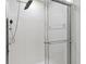 Modern bathroom shower featuring white tile and a glass door at 26922 White Plains Way, Leesburg, FL 34748