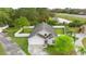 An aerial view showing the home's well-maintained lawn, gray roof, driveway, and convenient location near the road and pond at 580 Tree Shore Dr, Orlando, FL 32825