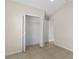 Well-lit bedroom featuring tile floors and a closet with folding doors and shelves at 580 Tree Shore Dr, Orlando, FL 32825