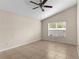 Cozy bedroom boasts tile flooring, a ceiling fan, and natural light from the window at 580 Tree Shore Dr, Orlando, FL 32825