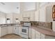 Kitchen with white cabinets, tile backsplash, and modern appliances for a functional cooking space at 580 Tree Shore Dr, Orlando, FL 32825