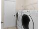 Functional laundry area with a washer and dryer with storage shelves at 580 Tree Shore Dr, Orlando, FL 32825