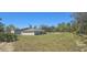 Expansive backyard featuring lush green grass with another home visible in the background at 422 St Johns Ln, Poinciana, FL 34759