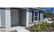 Close up of the front door with stone detail and black shutters at a single window at 53 Orchid Ct, Poinciana, FL 34759