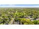 Expansive aerial view of a community with tree-lined streets and various residential homes under a bright sky at 1309 Sanford Ave, Sanford, FL 32771