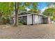 Quaint single-story home showcasing gray siding, white trim, a landscaped yard, and ample shade trees at 1309 Sanford Ave, Sanford, FL 32771