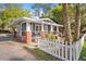 Quaint single-story home featuring gray siding, red brick accents, and a charming white picket fence at 1309 Sanford Ave, Sanford, FL 32771