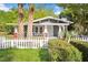 Charming home with gray siding, red brick accents, a white picket fence, and mature landscaping at 1309 Sanford Ave, Sanford, FL 32771