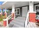 Close-up of front porch featuring brick columns, gray steps, and a classic white front door at 1309 Sanford Ave, Sanford, FL 32771