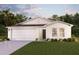 Charming single-story home with a well-manicured lawn and a two-car garage under a twilight sky at 12989 Se 53Rd Ave, Belleview, FL 34420