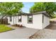 Side view of a modern, white, single-story home with a well-kept lawn and driveway at 760 S Park Ave, Winter Garden, FL 34787