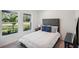 Bright bedroom featuring a plush bed with patterned pillows and view from two windows showing lush greenery at 540 Glade Ct, Kissimmee, FL 34758
