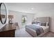 Well-lit bedroom with large bed, dresser, side table, chair and a view of the outdoors from the window at 540 Glade Ct, Kissimmee, FL 34758