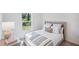 Bright bedroom featuring a plush bed with striped blanket, side table with lamp, and a view of green outdoors at 540 Glade Ct, Kissimmee, FL 34758