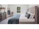 This bedroom features a plush, tufted headboard, a cozy blue quilt, and neutral decor, creating a serene and inviting space at 540 Glade Ct, Kissimmee, FL 34758