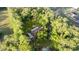 Drone view of a house surrounded by mature trees and overgrown yard at 1915 Poinsettia Dr, Port Orange, FL 32128