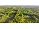 Lovely aerial view showcases the property's pool, green lawn, and proximity to a neighborhood surrounded by lush trees at 1915 Poinsettia Dr, Port Orange, FL 32128