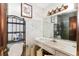 Bathroom with wallpaper, cabinet storage, sink, mirror and toilet at 1915 Poinsettia Dr, Port Orange, FL 32128