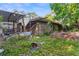 Side exterior view of a brick home with a covered carport and overgrown foliage at 1915 Poinsettia Dr, Port Orange, FL 32128