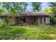 Outside view of a brick home with broken windows and overgrown greenery at 1915 Poinsettia Dr, Port Orange, FL 32128