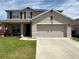 Charming two-story home featuring a two-car garage, well-maintained lawn, and inviting front porch at 308 Aberdeen Dr, Davenport, FL 33896
