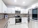 Modern kitchen with stainless steel appliances, white cabinets, and a stylish tile backsplash at 3514 Yacht Club Ct, Kissimmee, FL 34746