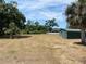Backyard with large green shed and palm trees at 6519 Shadowbrook Run, Lakeland, FL 33813