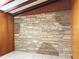 Close up of a decorative stone accent wall in a living room with wood paneled walls at 5801 Poinciana Ave, Lakeland, FL 33809
