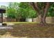 A spacious backyard with a large tree, a fence, and a shed at 5801 Poinciana Ave, Lakeland, FL 33809
