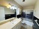 Clean bathroom features a black tile accent wall, shower with glass doors, and a large mirror at 5801 Poinciana Ave, Lakeland, FL 33809