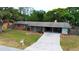 Charming single-story brick home with a carport and well-manicured lawn at 5801 Poinciana Ave, Lakeland, FL 33809