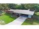 Appealing single-story home featuring a covered carport, a lush lawn, and a neatly landscaped front yard at 5801 Poinciana Ave, Lakeland, FL 33809