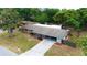 Single-story brick home featuring a carport, fenced backyard, and lovely landscaping at 5801 Poinciana Ave, Lakeland, FL 33809
