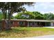 Beautiful single story brick home with well-manicured lawn and mature trees at 5801 Poinciana Ave, Lakeland, FL 33809