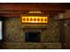 Close up of a stone fireplace in a living room with a stained glass light fixture and wood paneled walls at 5801 Poinciana Ave, Lakeland, FL 33809
