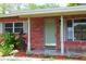 Charming brick home featuring a stylish front door, tiled porch and well maintained landscaping at 5801 Poinciana Ave, Lakeland, FL 33809